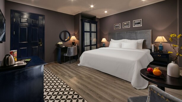 A modern hotel room with a large bed, bedside tables, a desk, and a chair. - Matilda Boutique and Spa Hotel (Hanoi)
