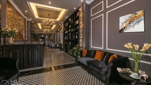 A modern interior with a black leather sofa, a dining area, and a library with bookshelves. - Matilda Boutique and Spa Hotel (Hanoi)