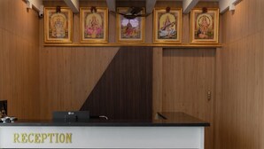 En reception med en lysekrone, indrammede religiøse malerier og et skilt der siger "RECEPTION".