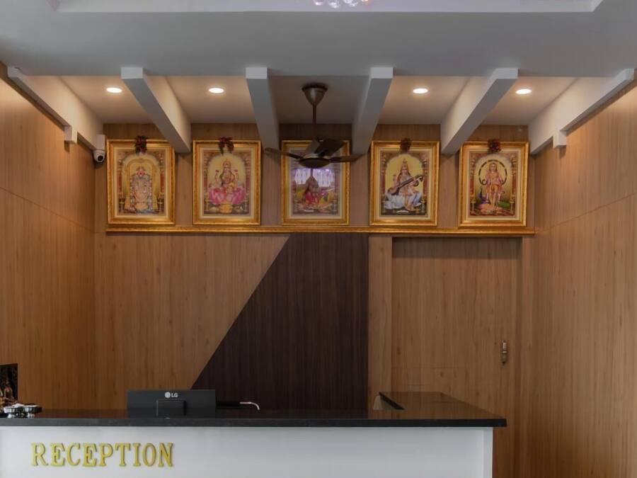 Un mostrador de recepción con una araña, cuadros religiosos enmarcados y un cartel que dice 'RECEPTION'.