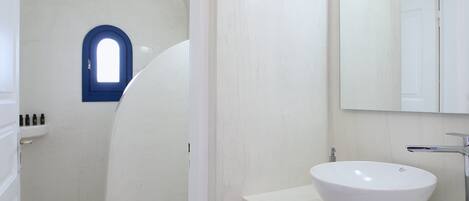 A bathroom with a white sink, a mirror, and a bathtub.