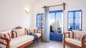 A room with a sofa, chairs, a curtain, and a door with blue shutters.