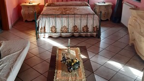 Une chambre à coucher avec un lit, deux tables de chevet avec des lampes, une commode et un tableau au mur.
