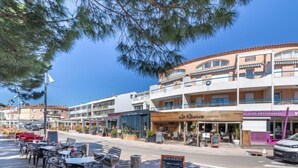 A coastal restaurant with outdoor seating, a wooden facade, and a view of the sea. - Les Jardins d'Hélios by Interhome (Carqueiranne)