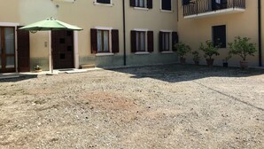 A building with multiple windows, a balcony, and potted plants. - Casa Olinda (Lazise)