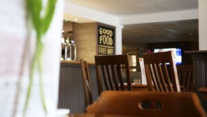 A restaurant interior with wooden chairs and a sign that reads "GOOD FOOD FREE WIFI". - The Fazeley Inn (Tamworth)