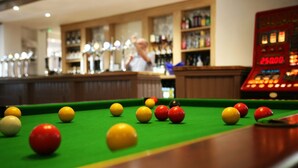 A pool table with balls and a red scoreboard in the background. - The Fazeley Inn (Tamworth)