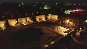 A nighttime view of a historic building with traditional architecture, including a large courtyard and a swimming pool. - Himmatgarh Palace (Jaisalmer)