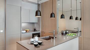 Una cocina moderna con una isla central, electrodomésticos de acero inoxidable e iluminación colgante.