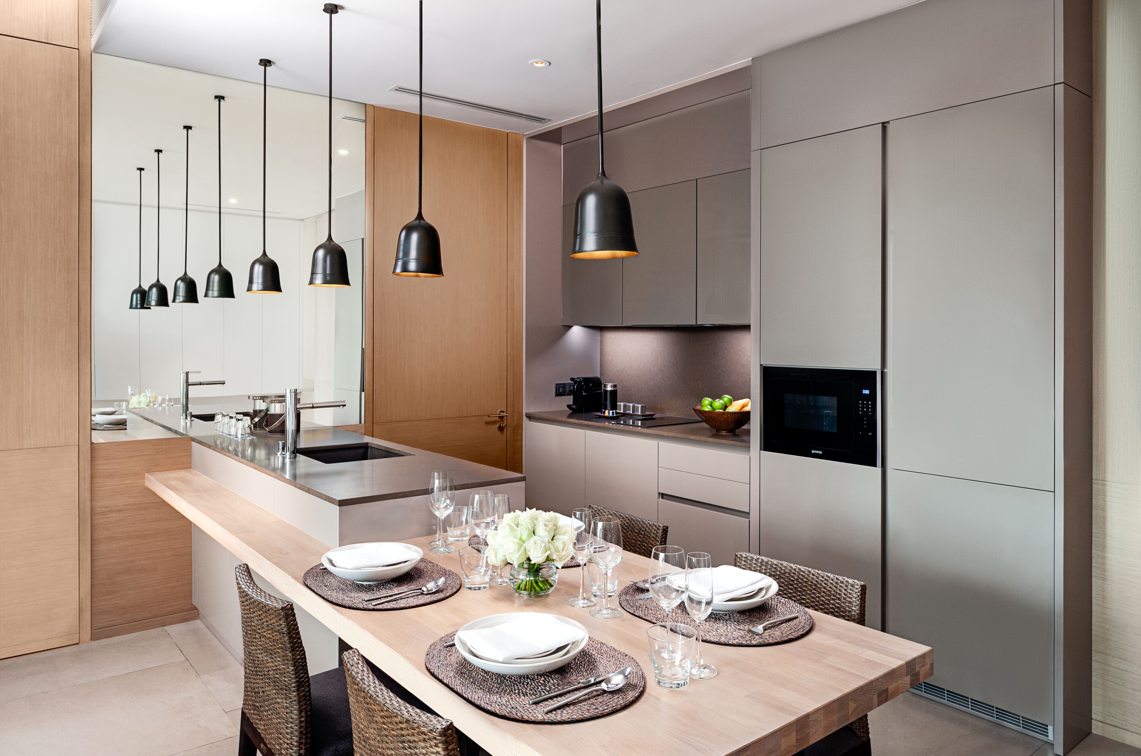 A modern kitchen with a central island, stainless steel appliances, and pendant lighting.