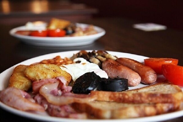 A plate of breakfast food including eggs, sausages, bacon, and toast.