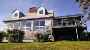 A two-story house with a balcony, a chimney, and a large window. - Quintessential Maine waterfront! (Biddeford)