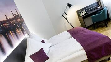 Une chambre d’hôtel avec un lit, un bureau et une chaise.