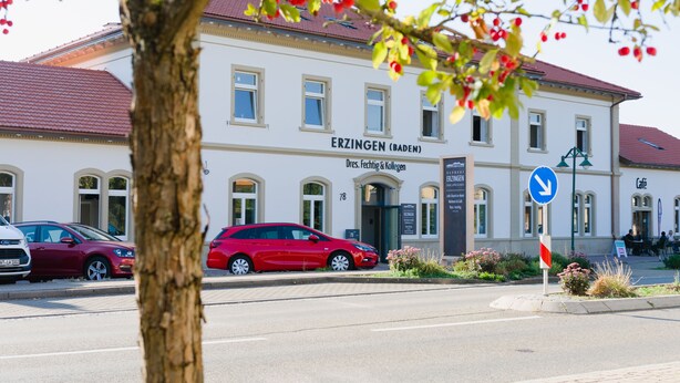A building labeled "ERZINGEN (BADEN)" with a red car parked in front. - Bahnhof ERZINGEN hotel coffee  & more (Klettgau)
