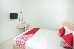 A neatly arranged bedroom with a bed, a desk, and a chair. - Hotel O Lapan Lapan (Banjarmasin)