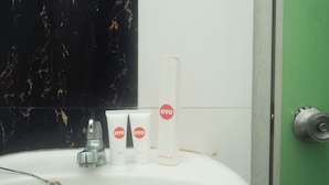 Ein Badezimmerwaschbecken mit weißer Marmorablage, einer grünen Tür und einem Dentalset auf dem Waschbecken.
