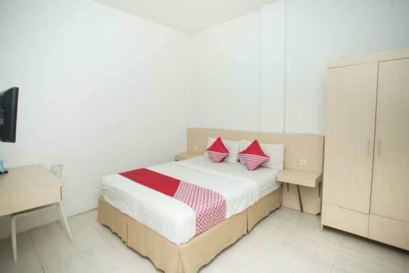 A bedroom with a bed, bedside table, and a wardrobe. - Hotel O Lapan Lapan (Banjarmasin)