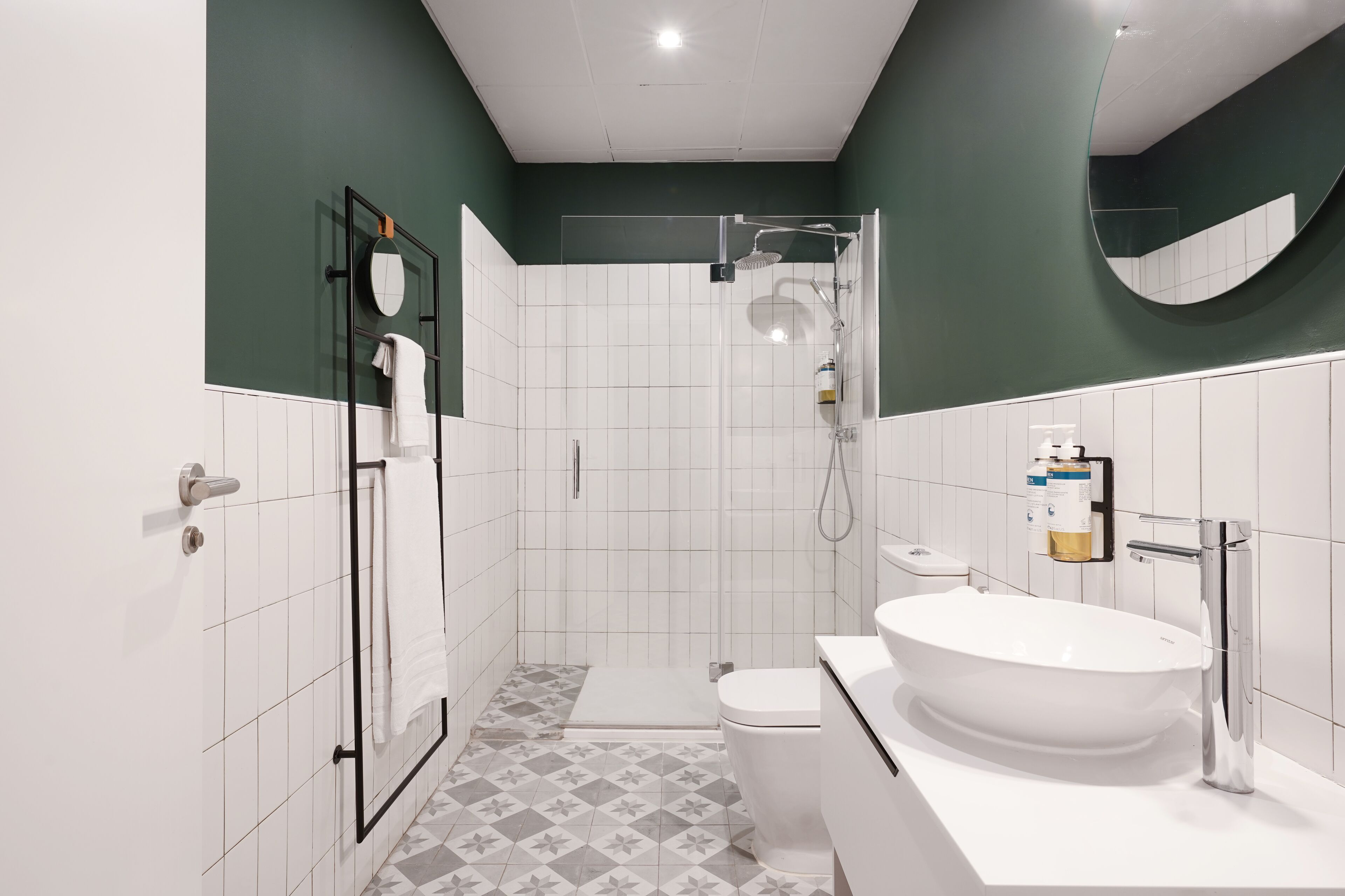 A modern bathroom with a glass-enclosed shower, a white sink, and a toilet.