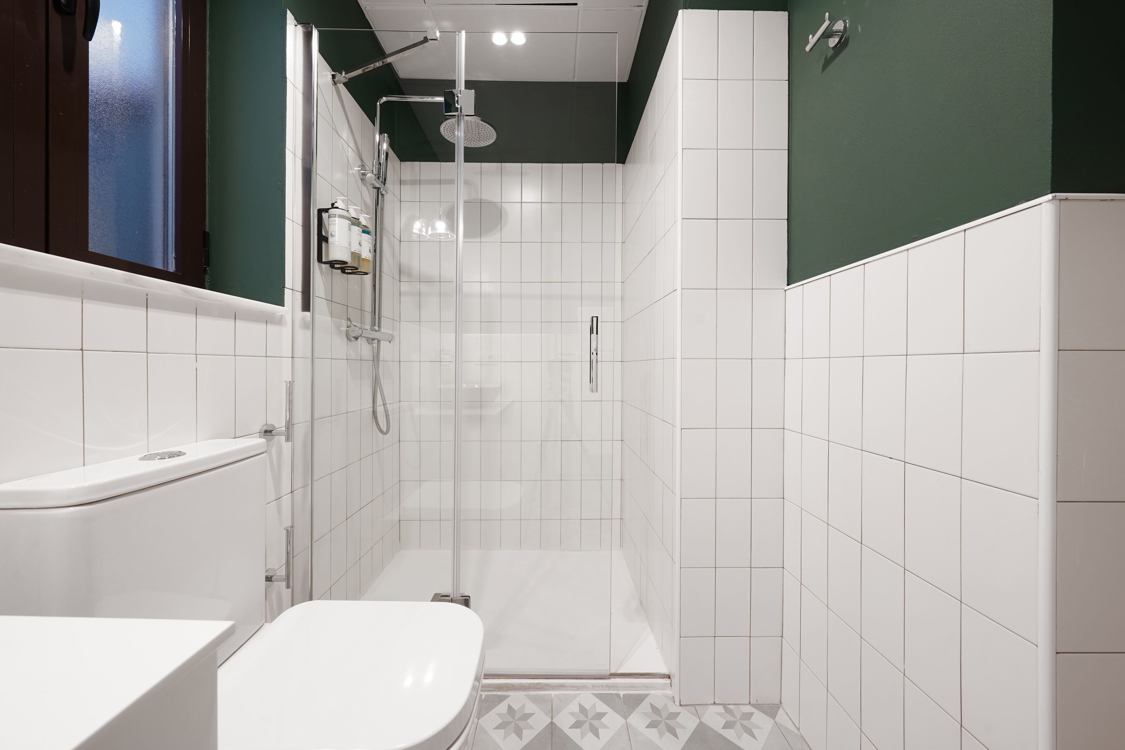 Een moderne badkamer met een douche, toilet en wastafel.