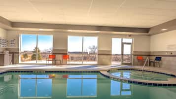 Relax by the pool surrounded by a view of the outdoors and comfortable seating.