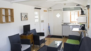 A compact living space with a kitchenette, a dining area, and a seating area with two chairs and a small table. - Holiday Home Sundslätt (Urshult)