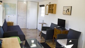 A living room with a sofa, chairs, a TV, a small table, and a cabinet. - Holiday Home Sundslätt (Urshult)