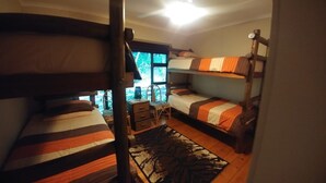 A bunk bed room with a small table and a window. - Campismo Ninho 23 (Ponta d'Ouro)