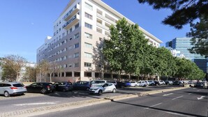Un hôtel à plusieurs étages, doté d’une façade plate, d’un parking et bordé d’arbres.
