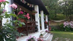 Un edificio blanco con un porche decorado con macetas y flores.