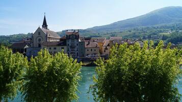 A historic town with a prominent church, river, and surrounding greenery.
