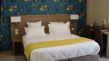 Una habitación de hotel con una cama grande, un escritorio y una silla.