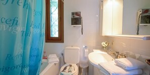 Un bagno con il water, lavandino e tenda per la doccia.
