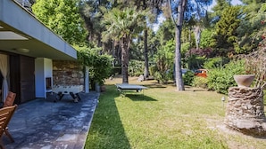 Ein modernes Haus mit Terrasse, einem Kicker und einem Tischtennis-Tisch.