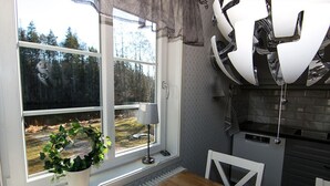 Eine Küche mit Fenster, einer Topfpflanze und einem modernen Kronleuchter.
