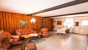 Ein gemütliches Wohnzimmer mit Ledersofas, einem Holzesstisch und einer Chandelier.