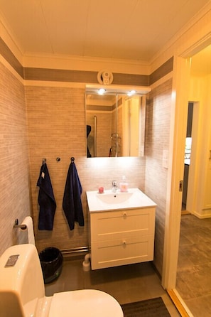 Ein kleines Badezimmer mit Waschbecken, Spiegel und Handtuchhalter.