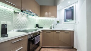 Een moderne keuken met een ingebouwde oven, een koffieapparaat en een raam boven de gootsteen.