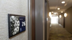 A hallway with a sign indicating room number 216. - Hampton Inn & Suites Dundee (Dundee)