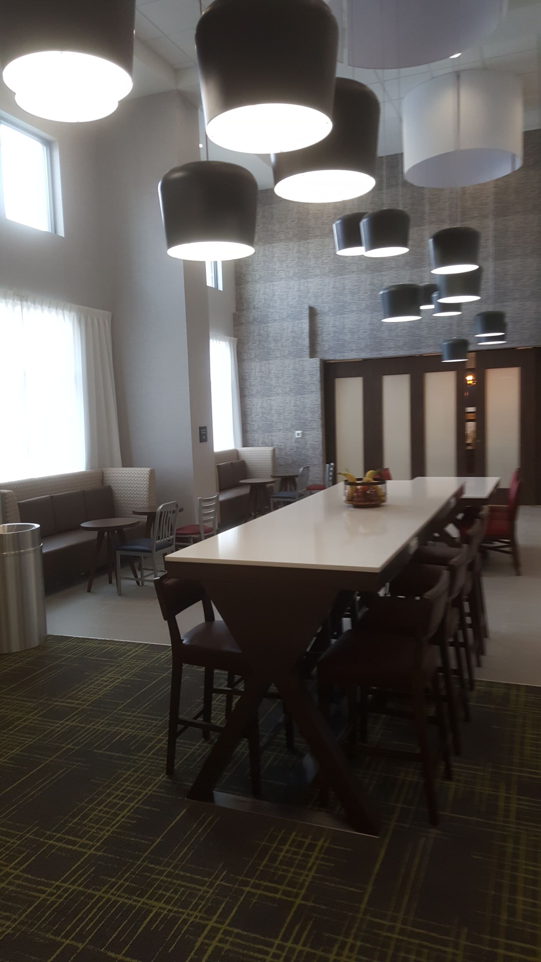 A conference room with a long table, several chairs, and pendant lighting.