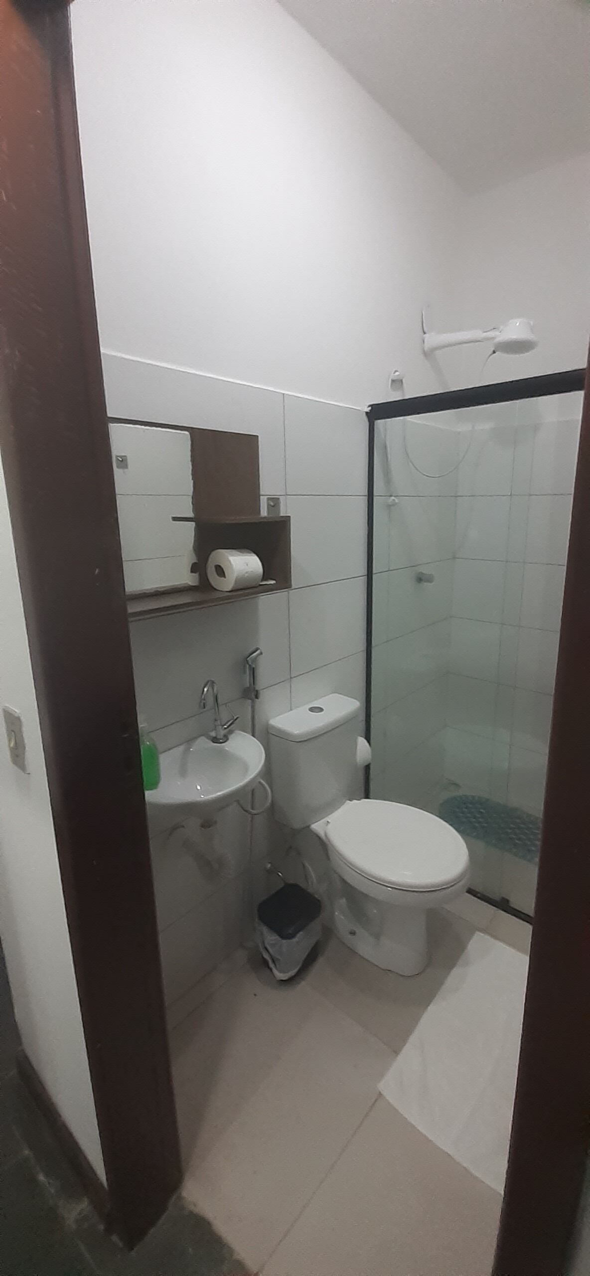 A small, modern bathroom with a toilet, sink, and shower.