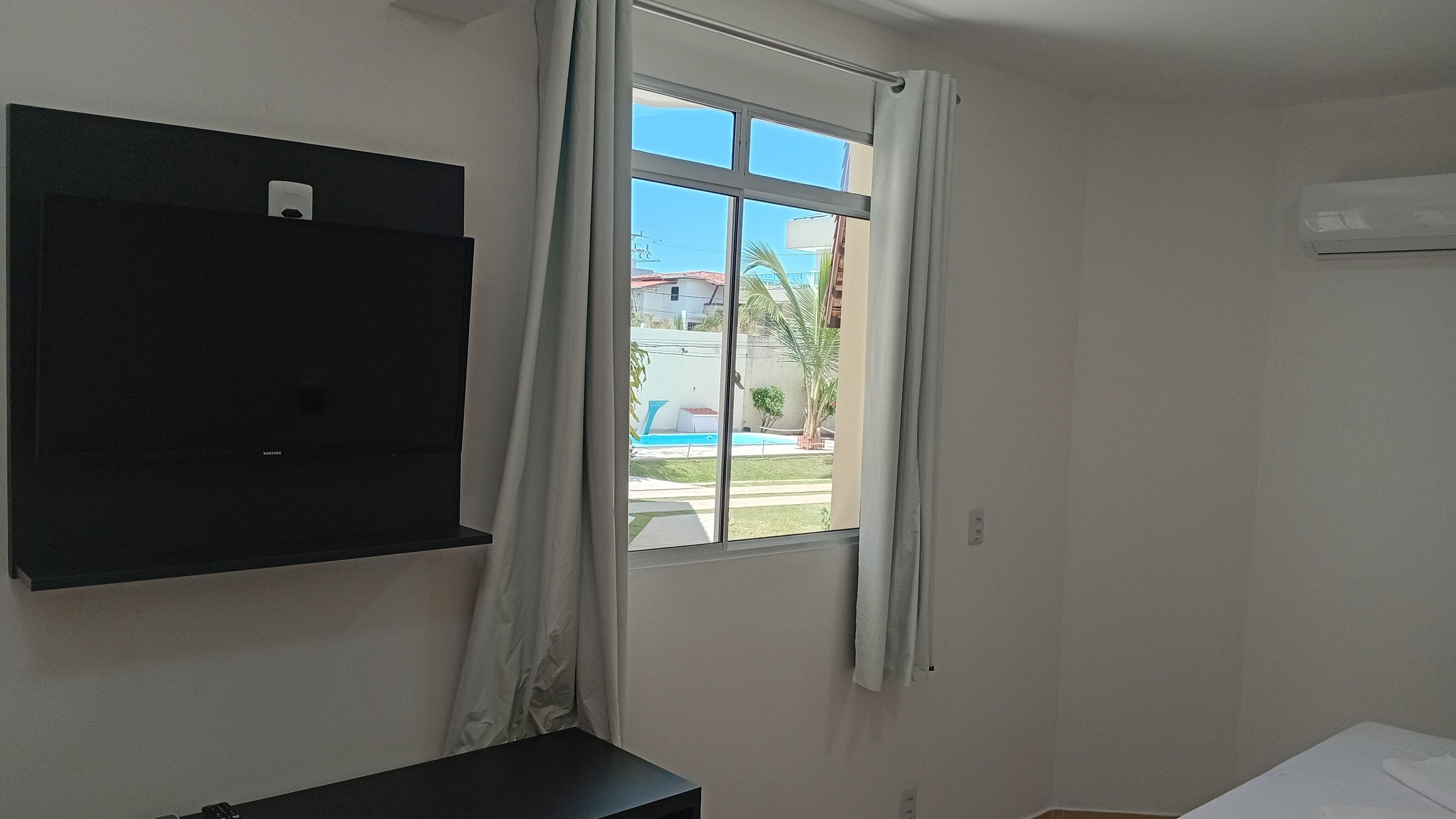 A room with a window, a black cabinet, and a white wall.