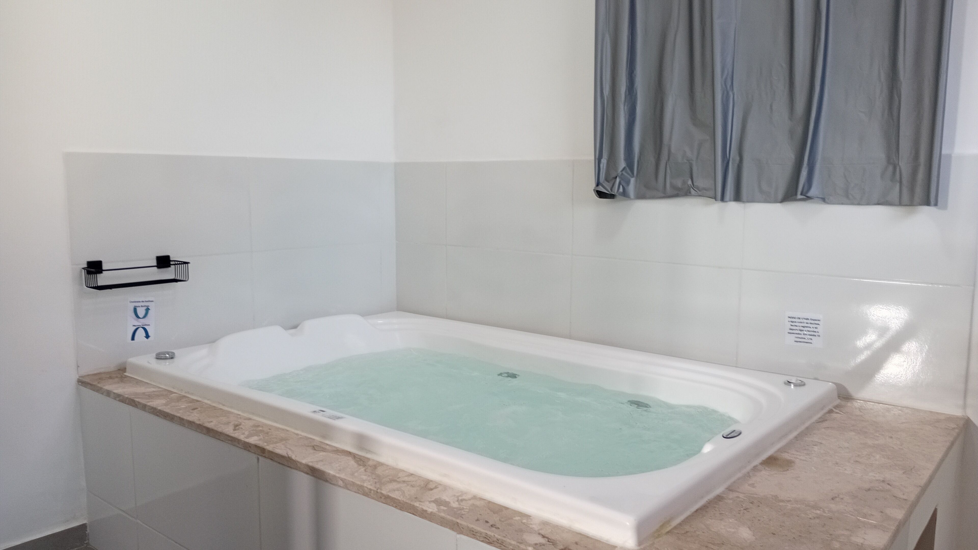 Um banheiro com banheira, porta-toalhas e cortina de chuveiro.