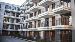 Een modern meerlaags woongebouw met balkons, grote ramen en een strak, eigentijds design.