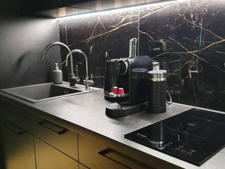A modern kitchen with a built-in sink, a coffee maker, and an induction cooktop.
