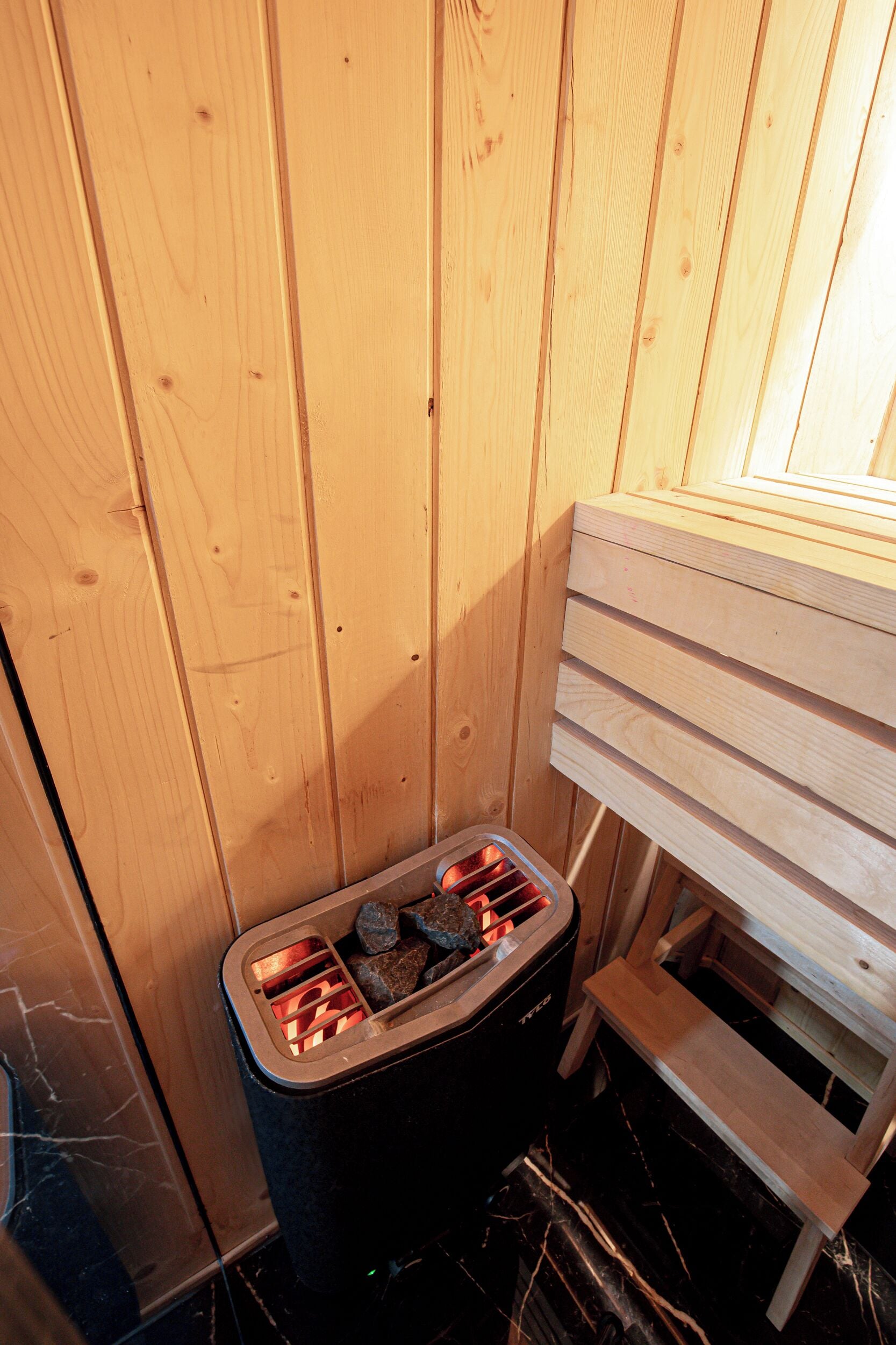 A sauna with wooden walls and a bench.