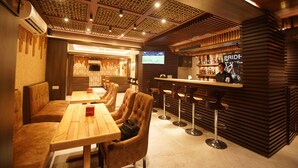 Eine moderne Bar mit Holzvertäfelung, einem Fernsehbildschirm und einer Bar.