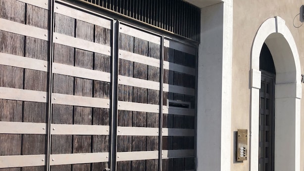 A modern building with a large metal gate and an arched entrance. - Rivadige Suite (Verona)