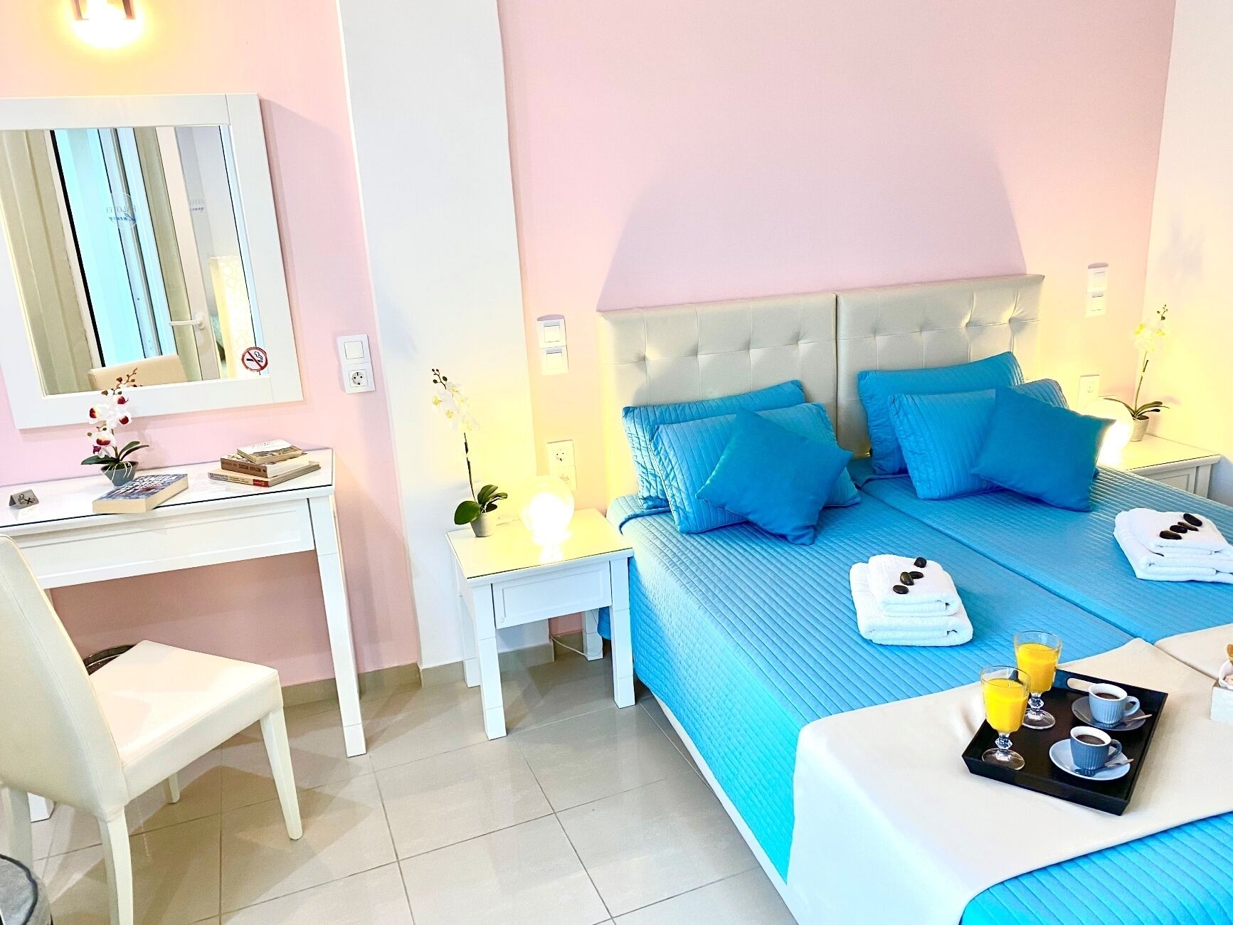 A hotel room with a bed, bedside tables, a desk, and a chair.