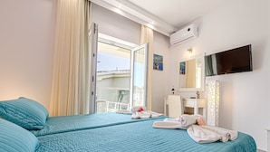 A hotel room with two beds, a balcony, a TV, and a bathroom. - Palotel Design Gouvia (Corfu)