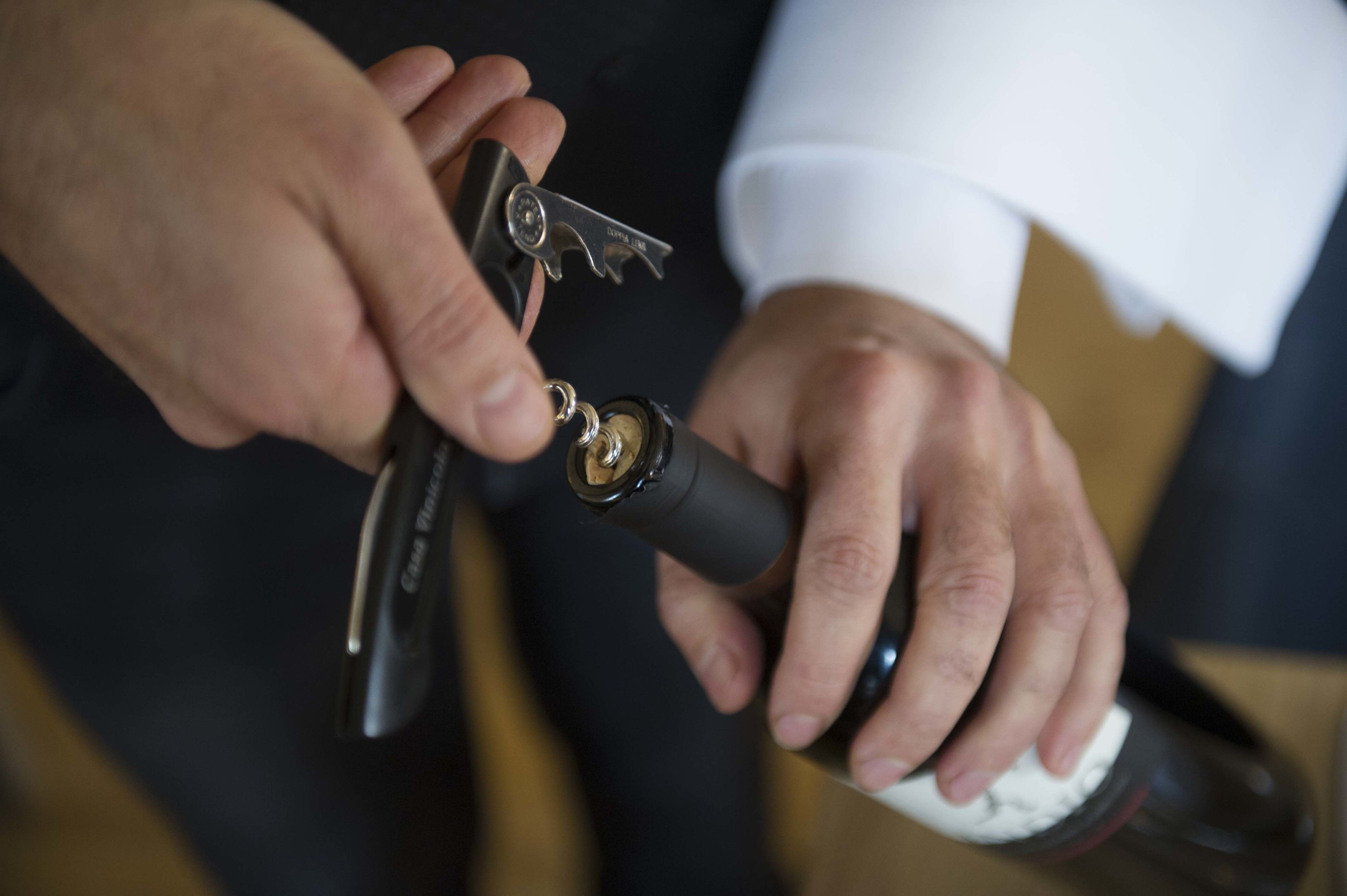A person using a bottle opener to open a bottle.